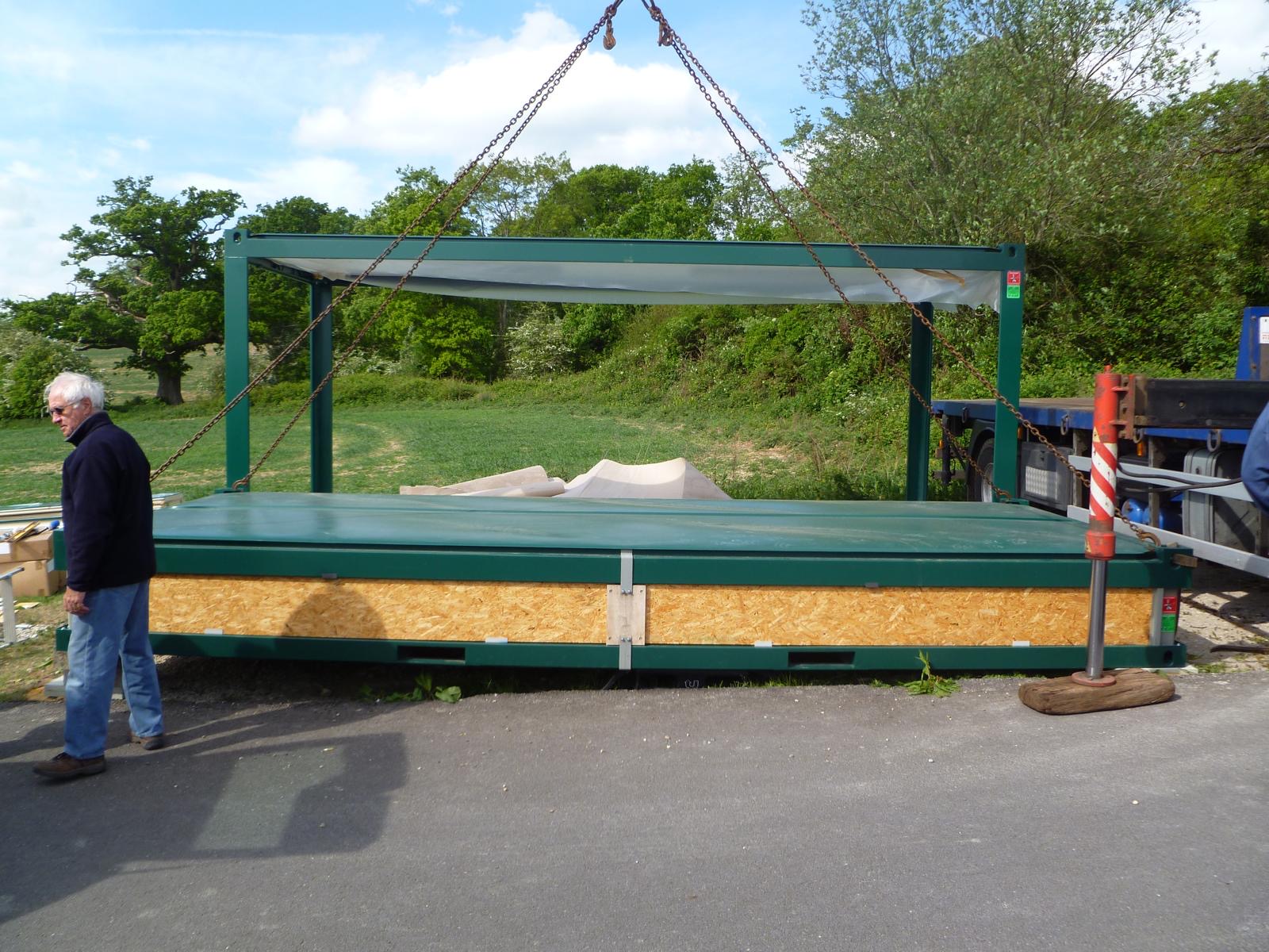 Flat-pack modular building section being craned from a delivery lorry